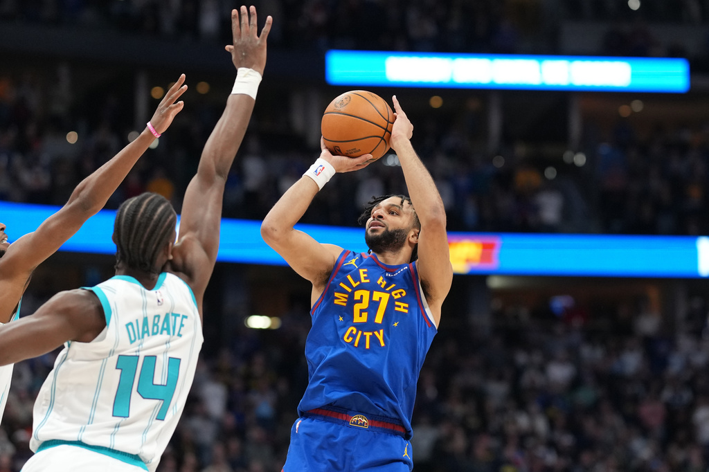Denver Nuggets guard Jamal Murray, right, looks to shoot for a basket over Charlotte Hornets forward Moussa Diabaté (14) in the first half of an NBA basketball game Sunday, Jan. 18, 2026, in Denver. (AP Photo/David Zalubowski)