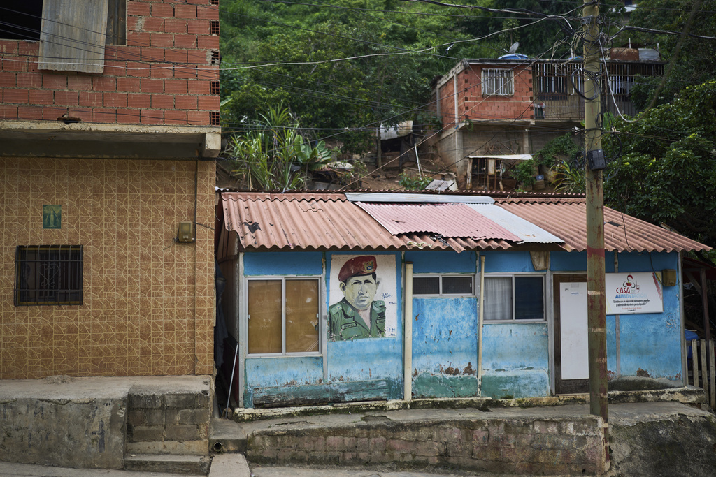 A mural of late Venezuelan President Hugo Chávez covers a wall at a government-run community kitchen in La Vega, on the outskirts of Caracas, Venezuela, Wednesday, July 2, 2025. (AP Photo/Ariana Cubillos)