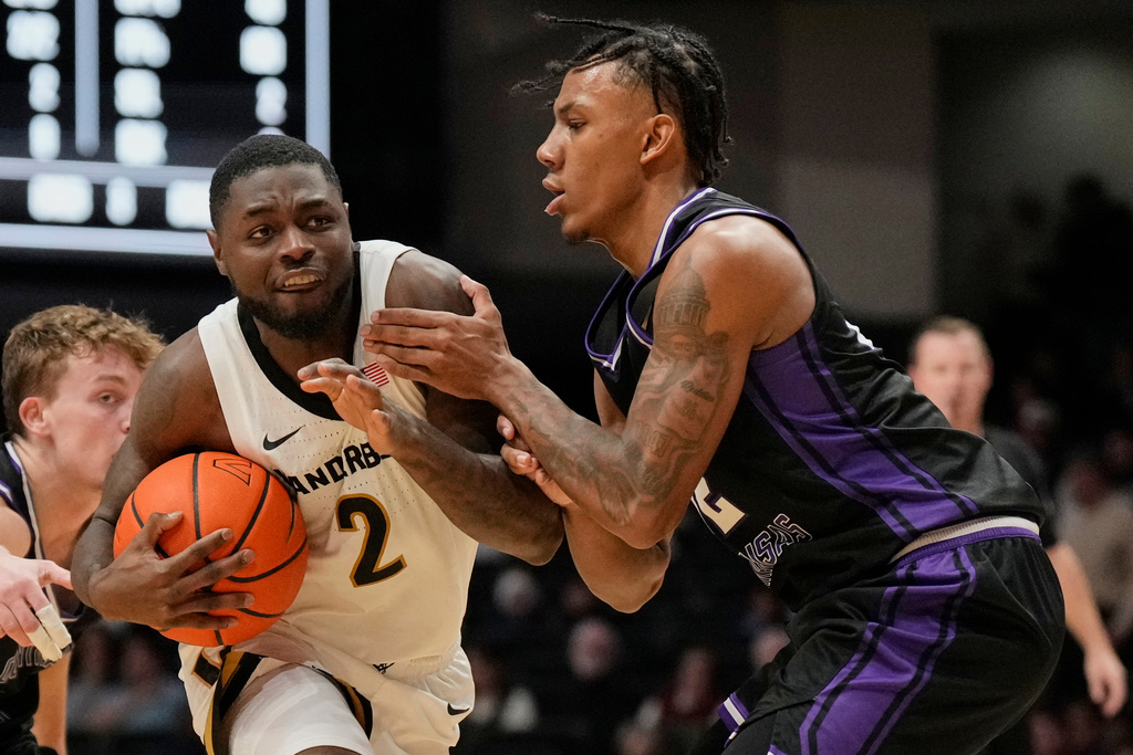 Vanderbilt guard Duke Miles (2) goes to the basket past Central Arkansas guard Luke Moore (32) during the first half of an NCAA college basketball game Saturday, Dec. 13, 2025, in Nashville, Tenn. (AP Photo/George Walker IV)
