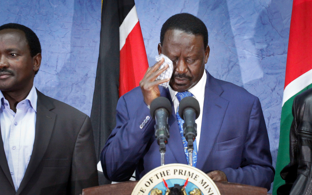 Losing presidential candidate Raila Odinga, right, wipes his brow as he speaks to the media and accepts the Supreme Court ruling upholding the election result, and urges unity amongst Kenyans, at a press conference in Nairobi, Kenya, Saturday, March 30, 2013. (AP Photo/Khalil Senosi)