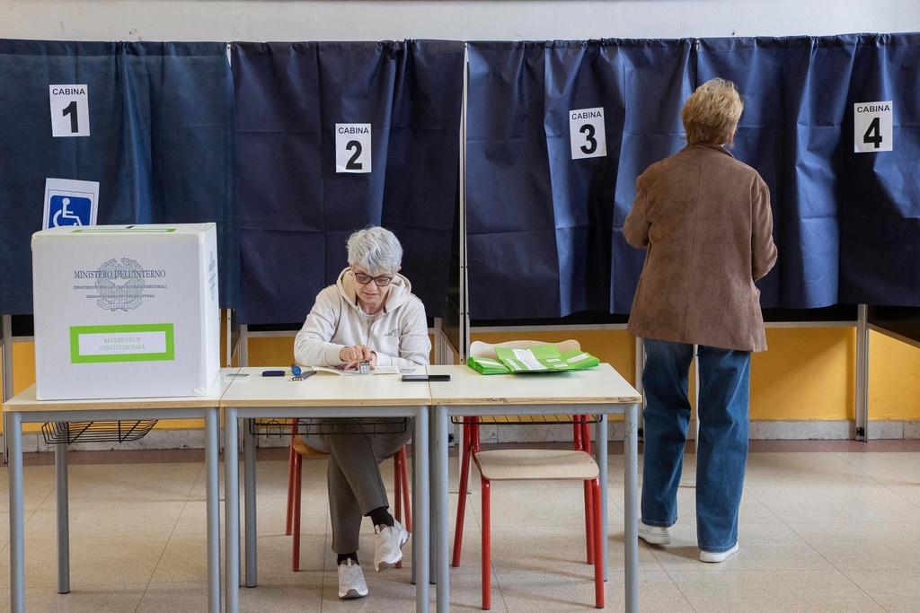 A woman arrives to vote in a referendum on judicial reform, at a polling station in Milan, Italy, Sunday March 22, 2026. (Marco Ottico/Lapresse via AP)