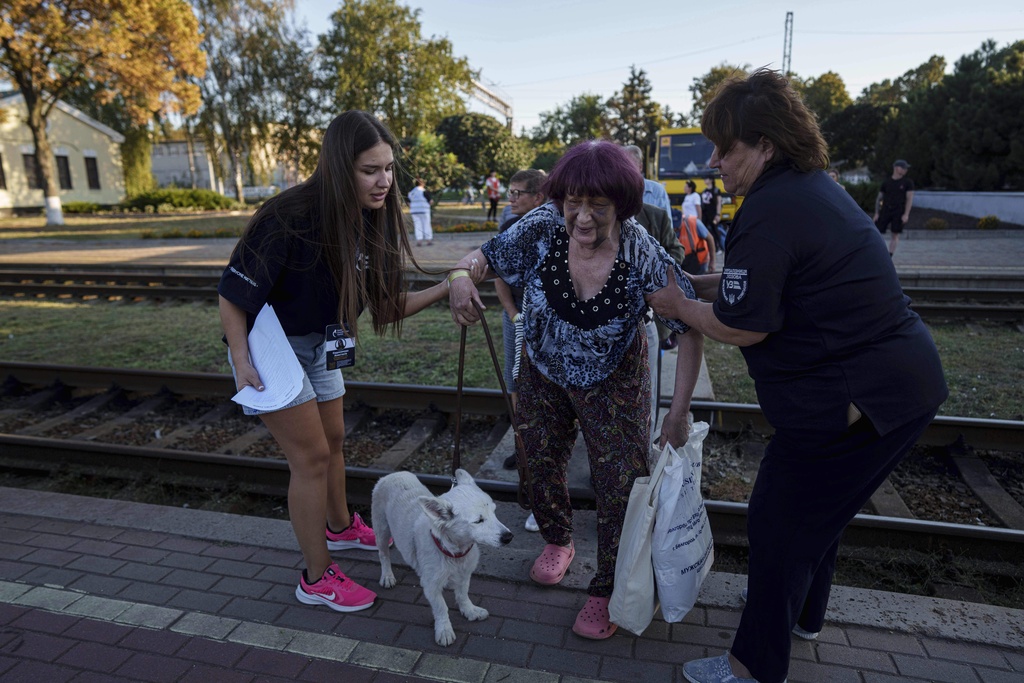 Tetiana Zaichikova, center, walks on a platform during evacuation at the train station in Lozova, Ukraine, Wednesday, Sept. 3, 2025. (AP Photo/Evgeniy Maloletka)
