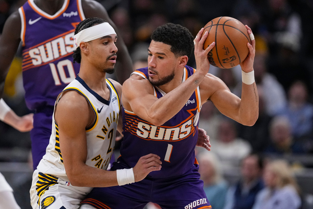 Indiana Pacers guard Andrew Nembhard (2) defends Phoenix Suns guard Devin Booker (1) during the first half of an NBA basketball game in Indianapolis, Thursday, March 12, 2026. (AP Photo/Michael Conroy)