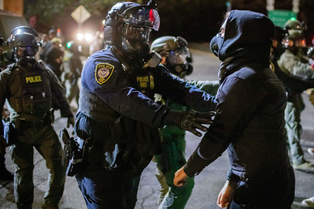Protesters confront federal law enforcement officers outside a U.S. Immigration and Customs Enforcement facility in Portland, Ore., Monday, Oct. 6, 2025. (AP Photo/Ethan Swope)