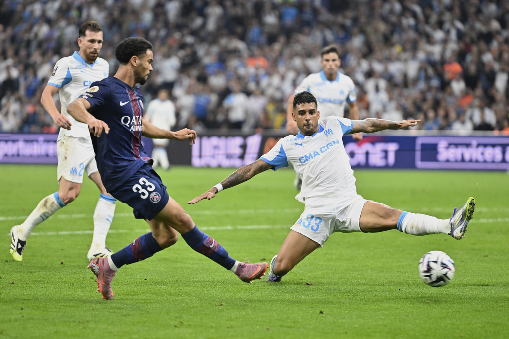 PSG's Warren Zaire-Emery kicks the ball ahead of Marseille's Emerson Palmieri during the French League One soccer match between Marseille and Paris Saint-Germain at Orange Velodrome in Marseille, France, Monday, Sept. 22, 2025. (AP Photo/Philippe Magoni)