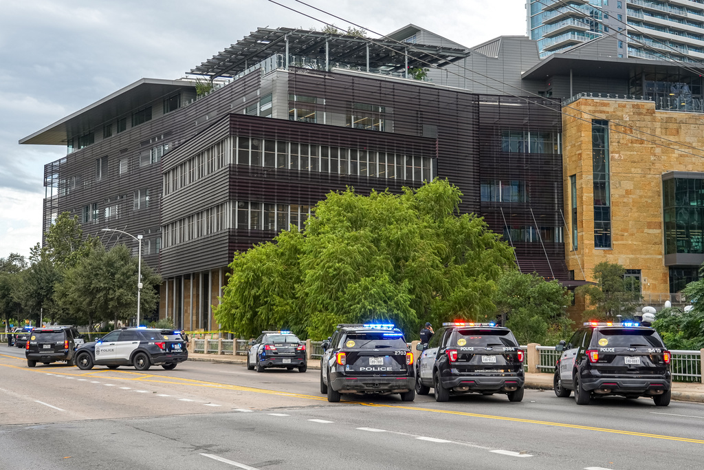 Police vehicles block the street after reports of a shooting at the Austin Public Library on César Chávez Street in downtown Austin, Texas on Saturday, Oct. 25, 2025. (Aaron E. Martinez/Austin American-Statesman via AP)