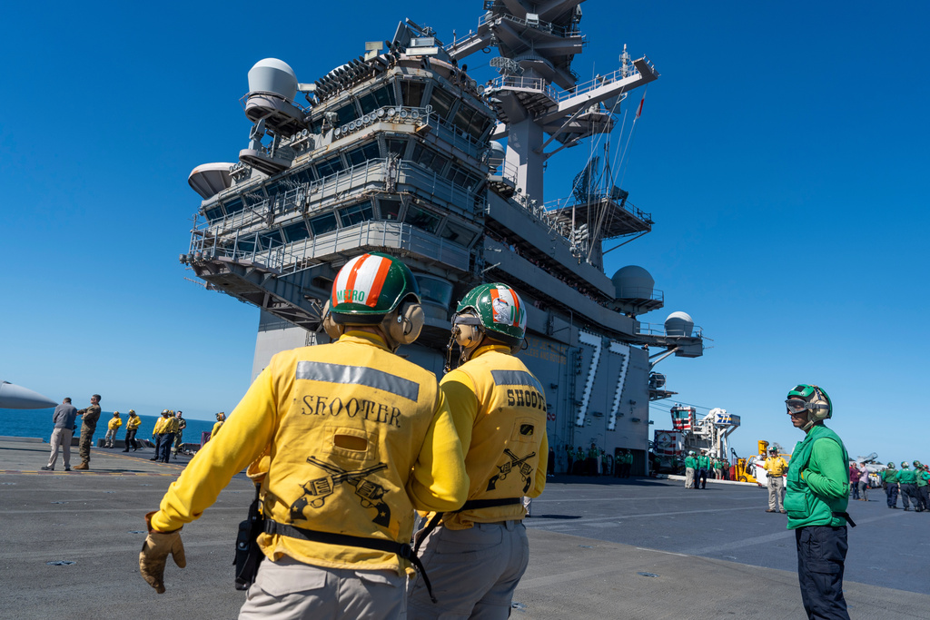 Crew members stand on the flight deck aboard the USS George H.W. Bush aircraft carrier in the Atlantic Ocean off the coast of Norfolk, Va., Saturday, Oct. 4, 2025. (AP Photo/Alex Brandon, File)