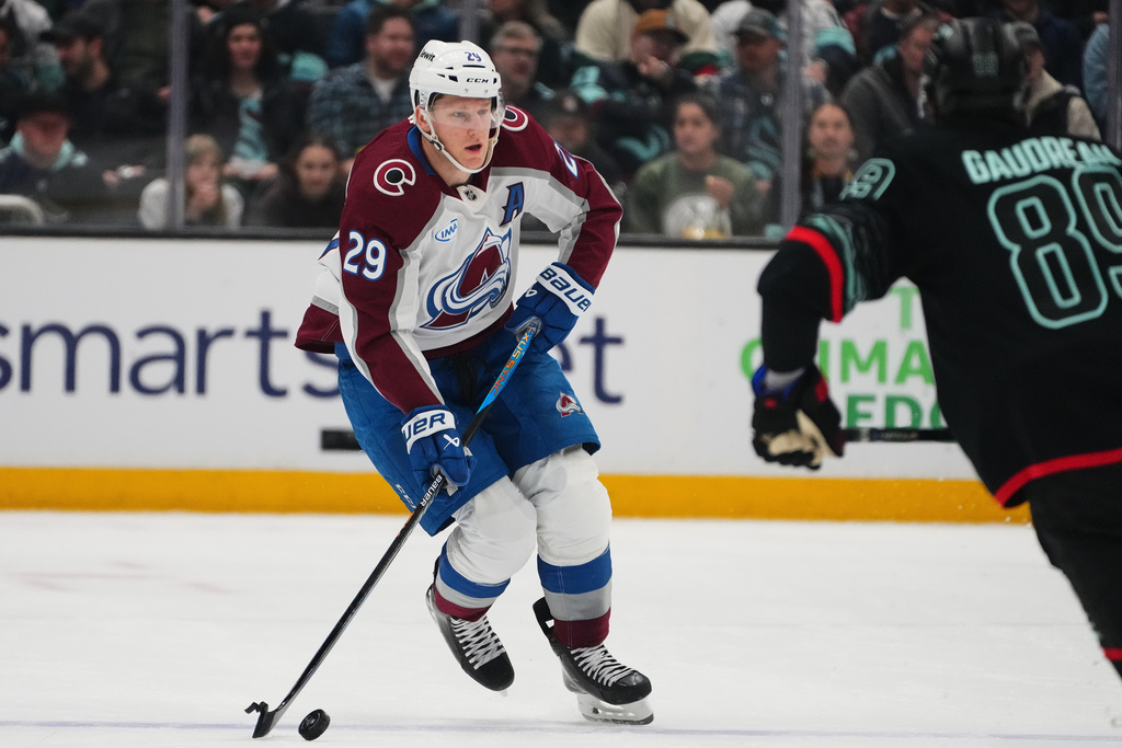 Colorado Avalanche center Nathan MacKinnon (29) moves the puck against Seattle Kraken center Frederick Gaudreau (89) during the first period of an NHL hockey game Thursday, March 12, 2026, in Seattle. (AP Photo/Lindsey Wasson)