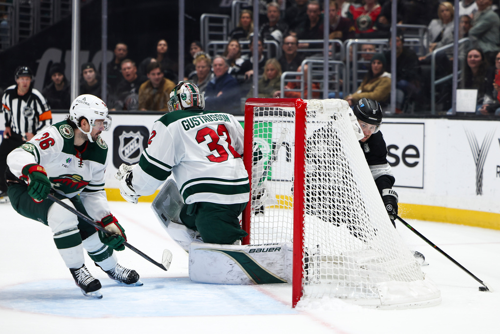 Los Angeles Kings right wing Adrian Kempe, right, skates around the goal as Minnesota Wild right wing Mats Zuccarello (36) watches and goaltender Filip Gustavsson (32) looks on during the second period of an NHL hockey game, Monday, Jan. 5, 2026, in Los Angeles. (AP Photo/Jessie Alcheh)