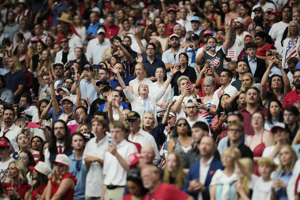 People listen during a worship song before the start of a memorial for conservative activist Charlie Kirk, Sunday, Sept. 21, 2025, at State Farm Stadium in Glendale, Ariz. (AP Photo/John Locher)