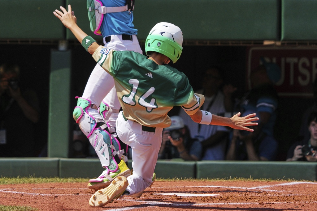 Taiwan's Chen Shi-Hong (14) slides safely into home plate behind Aruba's catcher Isaac Arendsz on a hit by Muhammad Zaman off Aruba's Jayderick Wederfoor during the third inning of the International Championship baseball game at the Little League World Series tournament in South Williamsport, Pa., Saturday, Aug. 23, 2025. (AP Photo/Gene J. Puskar)