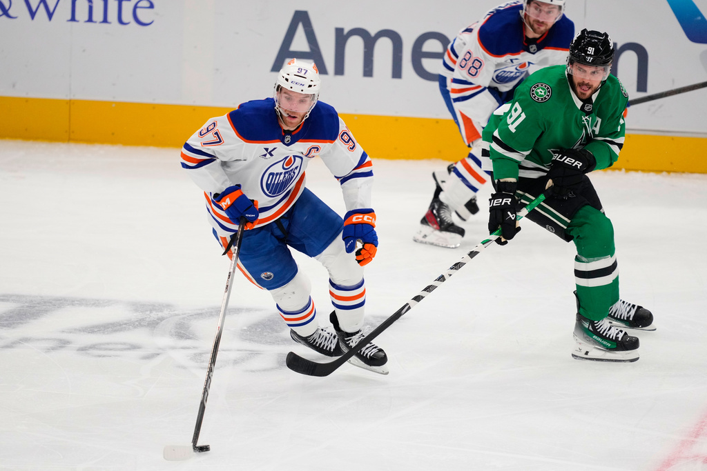 Edmonton Oilers center Connor McDavid (97) controls the puck in front of Dallas Stars' Tyler Seguin (91) in the third period of an NHL hockey game Tuesday, Nov. 4, 2025, in Dallas. (AP Photo/Tony Gutierrez)