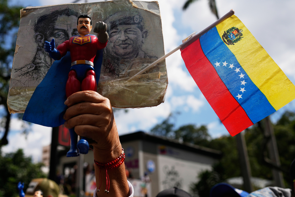 A government supporter holds an action figure of Super Bigote during a protest demanding the release of President Nicolas Maduro, who was captired by U.S. forces, in Caracas, Venezuela, Sunday, Jan. 4, 2026. (AP Photo/Ariana Cubillos)