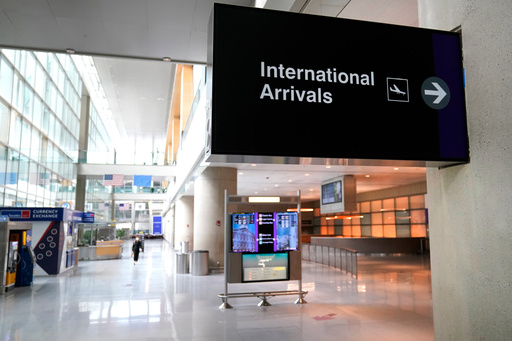 FILE - A sign directs travelers to the international arrival area of a nearly empty Terminal E, where most international flights arrive and depart, at Logan Airport in Boston, Sept. 29, 2020. (AP Photo/Charles Krupa, file) FILE - A sign directs travelers to the international arrival area of a nearly empty Terminal E, where most international flights arrive and depart, at Logan Airport in Boston, Sept. 29, 2020. (AP Photo/Charles Krupa, file)