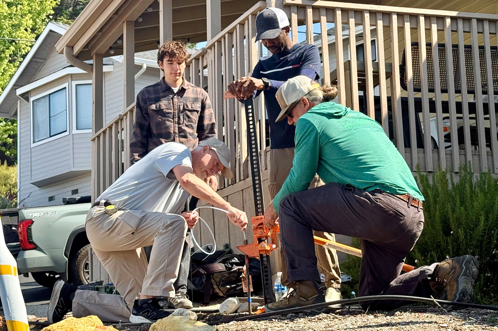 Scientists take samples from the soil Thursday, May 7, 2026, from the neighboring yard of a home in Arroyo Grande, Calif., connected to the man convicted of killing Kristin Smart as part of a sheriff's investigation. (AP Photo/Haven Daley) CORRECTION: Corrects from authorities to scientists