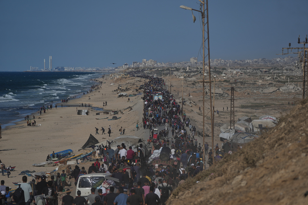 Displaced Palestinians walk with their belongings along the coastal road near Wadi Gaza in the central Gaza Strip, moving toward Gaza City, Friday, Oct. 10, 2025, after Israel and Hamas have agreed to a pause in their war and the release of the remaining hostages. (AP Photo/Abdel Kareem Hana)