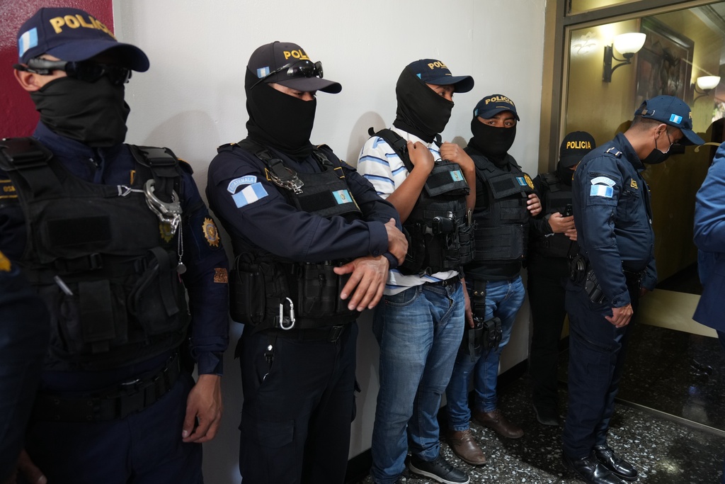 Police officers stand by as Attorney General agents conduct a raid at Club La Aurora where Bar Association members were meeting to vote for representatives to serve on the Constitutional Court, in Guatemala City, Thursday, Feb. 12, 2026.(AP Photo/Moises Castillo)