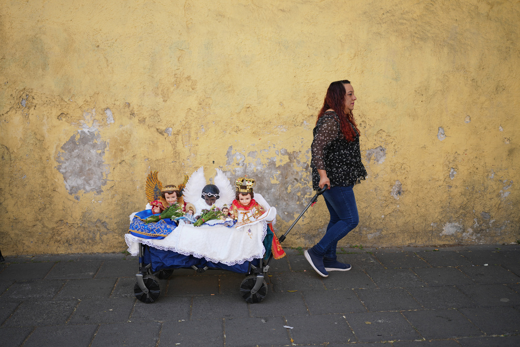 FILE - A woman pulls a cart with Baby Jesus figurines on Candlemas Day at the Xochimilco Catholic Church in Mexico City, Feb. 2, 2026. (AP Photo/Eduardo Verdugo, File)
