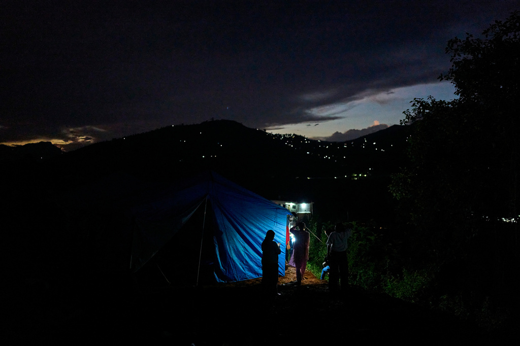 A flood affected woman stands outside temporary shelters for survivors in Nuwakot, Nepal, Tuesday, Sept. 22, 2026. (AP Photo/Niranjan Shrestha)