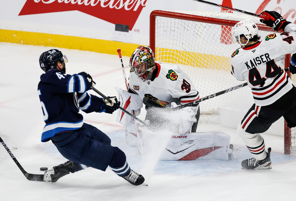 Chicago Blackhawks goaltender Spencer Knight (30) saves the shot from Winnipeg Jets' Cole Koep. (John Woods/The Canadian Press via AP)