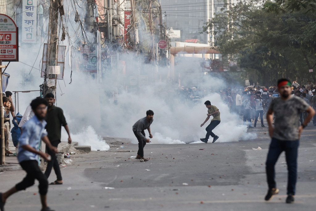 Protesters throw stones and shout slogans during a standoff with police outside the demolished residence of Sheikh Mujibur Rahman, Bangladesh's former leader and the father of the country's ousted Prime Minister Sheikh Hasina following the verdict against her, in Dhaka, Bangladesh, Monday, Nov. 17, 2025. (AP Photo/ Rajib Dhar)