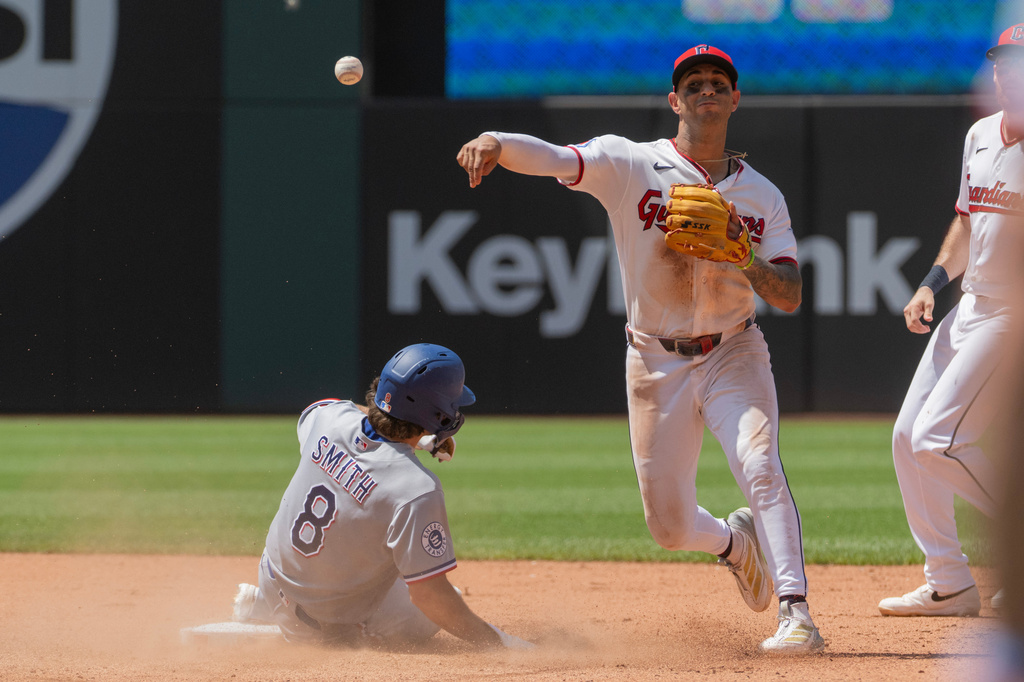 Cleveland Guardians' Brayan Rocchio, right forces Texas Rangers Josh Smith at second base but his throw to first was not in time to complete a double play during the sixth inning of a baseball game, Wednesday, July 1, 2026, in Cleveland. (AP Photo/Phil Long)