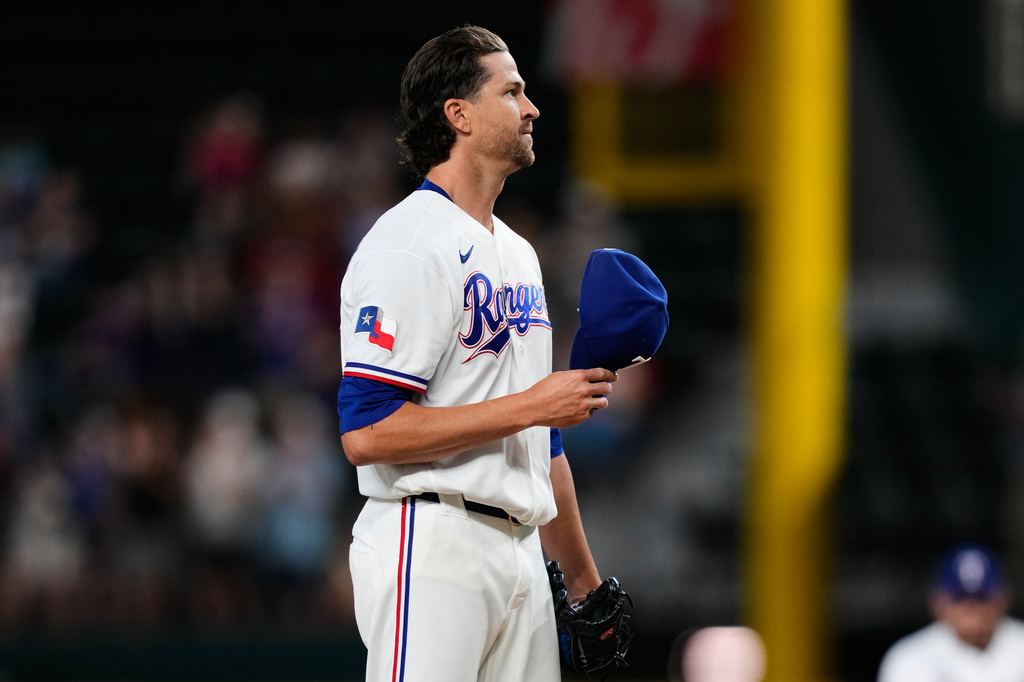 Texas Rangers pitcher Jacob deGrom acknowledges cheers from fans after striking out Washington Nationals' Abimelec Ortiz to earn his 2,000th career strikeout in the first inning of a baseball game Thursday, Aug. 20, 2026, in Arlington, Texas. (AP Photo/Tony Gutierrez)