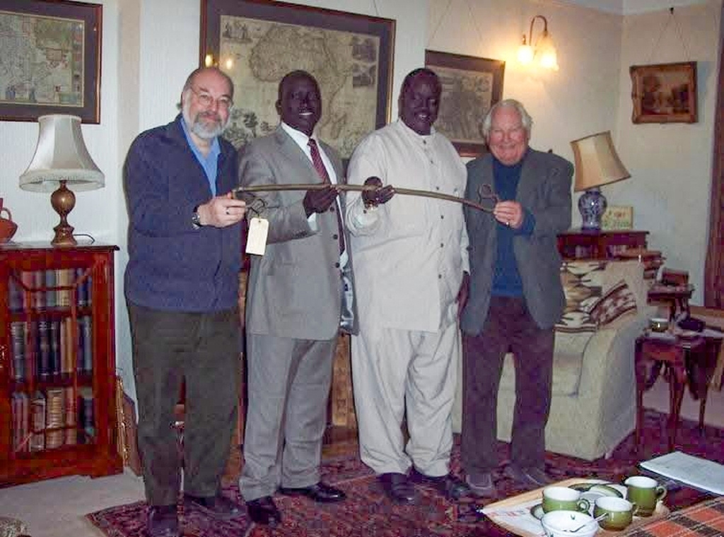 In this undated handout photo from Professor Wendy James Estate, from left, Douglas H. Johnson, Husein Mar, Rev. Gabriel Gai Riam and Philip Lyon Roussel hold the sacred stick also known as Ngundeng Bong's dang. (AP Photo/Wendy James Estate)