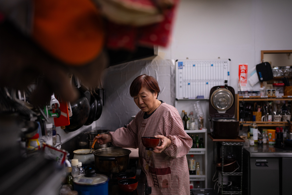 Tomoko Kobayashi serves miso soup during breakfast service at Futabaya Ryokan in Odaka, Fukushima Prefecture, Friday, Feb. 13, 2026. (AP Photo/Louise Delmotte)