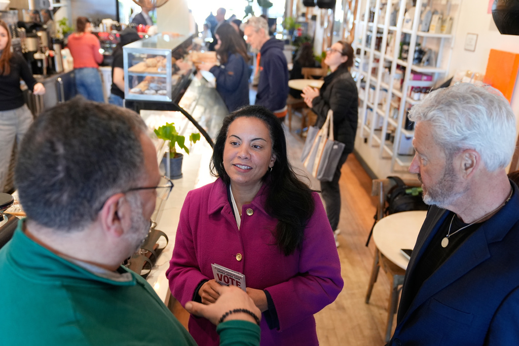 Analilia Mejia, the Democratic candidate running for New Jersey's 11th congressional district, talks to people at coffee shop in Morristown, N.J., Tuesday, March 24, 2026. (AP Photo/Seth Wenig)