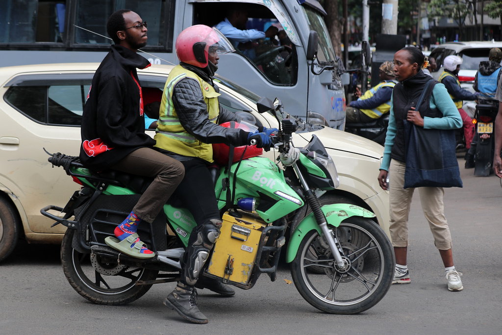 Men ride an electric Spiro motorcycle in Nairobi, Kenya, Tuesday, Feb. 24, 2026. (AP Photo/Henry Naminde)