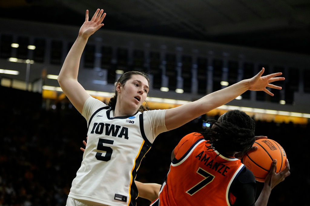 Iowa center Ava Heiden (5) tries to block a shot by Virginia forward Tabitha Amanze (7) during the first half in the second round of the NCAA college basketball tournament, Monday, March 23, 2026, in Iowa City, Iowa. (AP Photo/Charlie Neibergall)