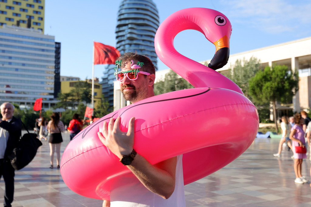 A protester holds an inflatable flamingo during a protest against plans for a luxury construction project linked to U.S. President Donald Trump's son-in-law, Jared Kushner, in Tirana, Albania, Saturday, July 4, 2026.(AP Photo/Hameraldi Agolli)