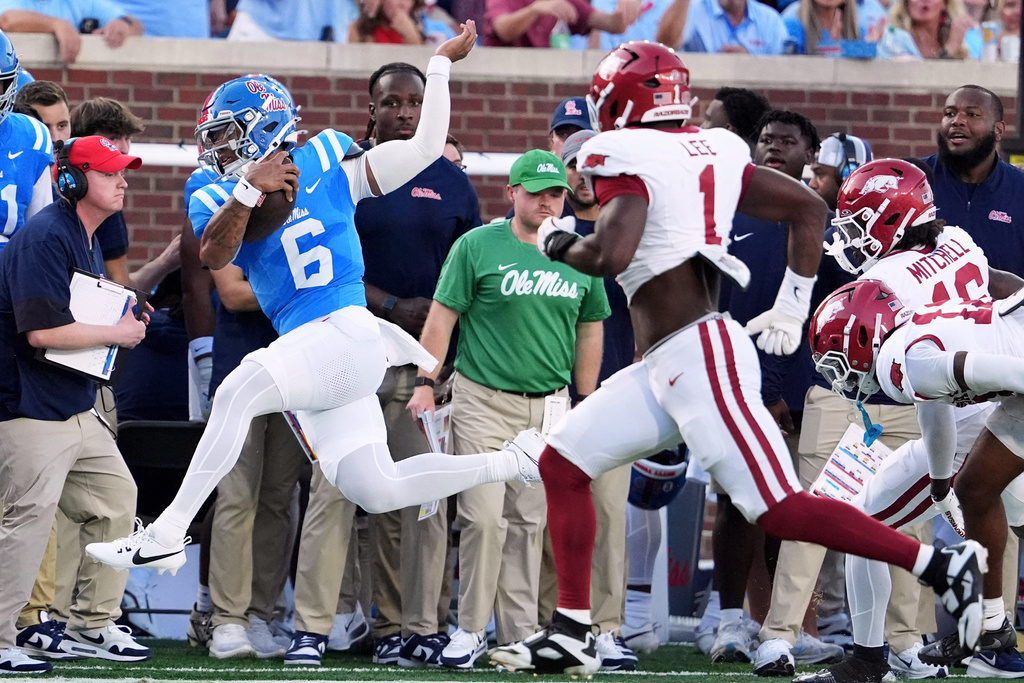 Mississippi quarterback Trinidad Chambliss (6) runs out of bounds for a first down pursued by Arkansas defensive lineman Phillip Lee (1) during the first half of an NCAA college football game in Oxford, Miss., Saturday, Sept. 13, 2025. (AP Photo/Rogelio V. Solis)
