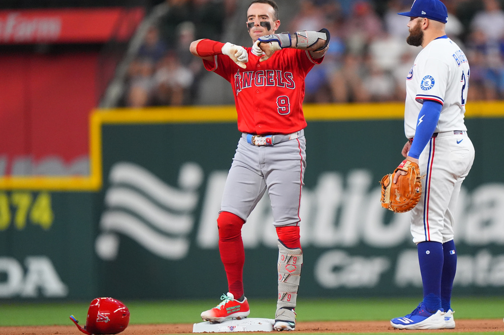Los Angeles Angels' Zach Neto (9) reacts from second base next to Texas Rangers first baseman Jake Burger (21) after hitting a double during the first inning of a baseball game, Saturday, Aug. 22, 2026, in Arlington, Texas. (AP Photo/LM Otero)