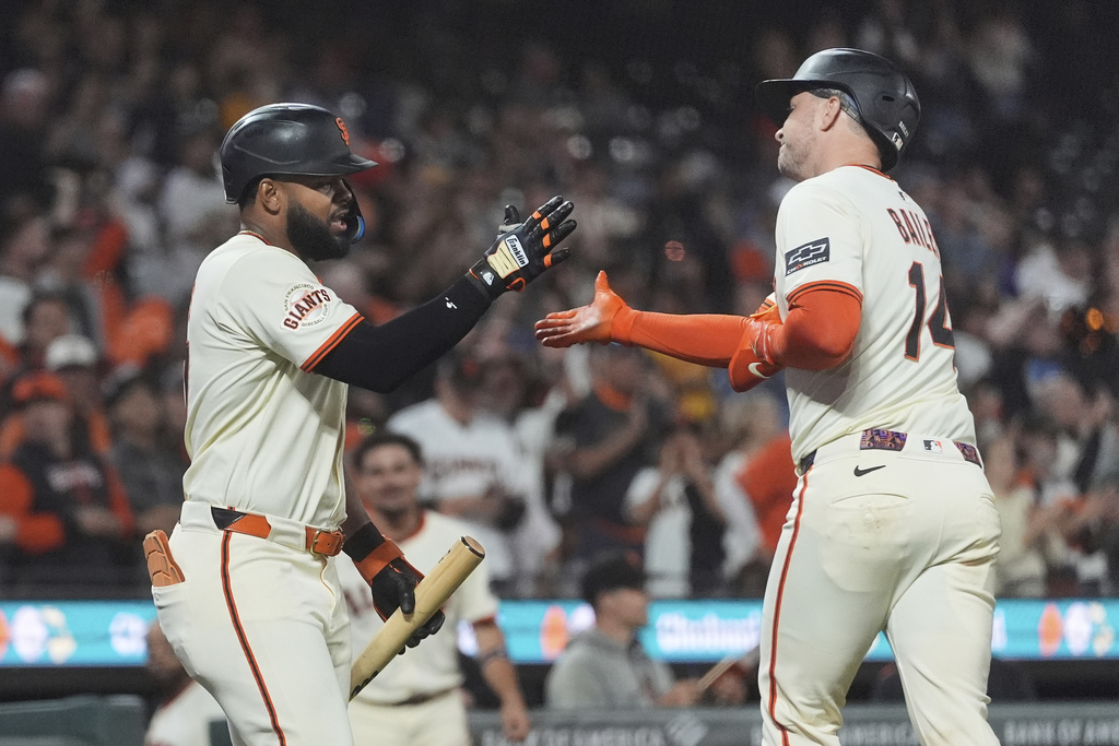 San Francisco Giants' Patrick Bailey, right, is congratulated by Heliot Ramos after hitting a home run against the Arizona Diamondbacks during the eighth inning of a baseball game in San Francisco, Monday, Sept. 8, 2025. (AP Photo/Jeff Chiu)