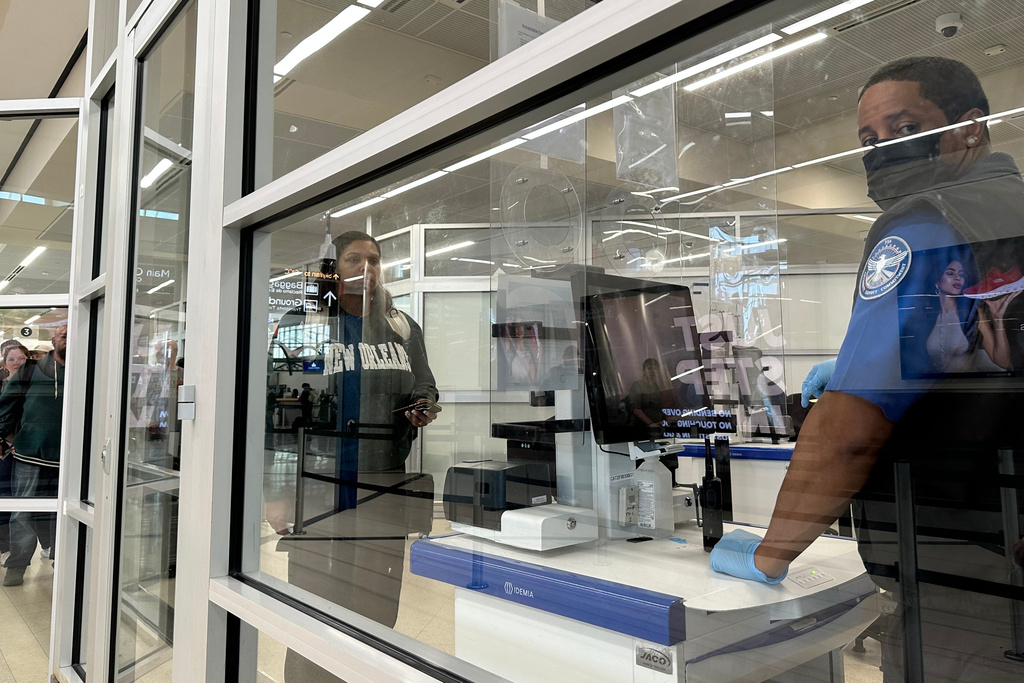 A Transportation Security Administration agent checks a passenger's identification at Hartsfield-Jackson International Airport on Saturday, March 21, 2026. (AP Photo/Jeff Amy)