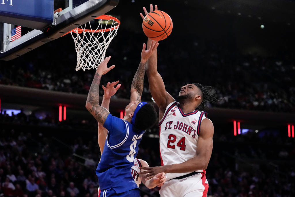 St. John's forward Zuby Ejiofor (24) blocks Seton Hall guard Adam Clark (0) during the second half of an NCAA college basketball game in the semifinals of the Big East tournament, Friday, March 13, 2026, in New York. (AP Photo/Yuki Iwamura)