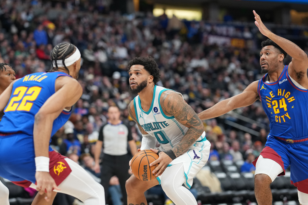 Charlotte Hornets forward Miles Bridges, center, drives to the net between Denver Nuggets forward Zeke Nnaji, left, and guard Jalen Pickett in the second half of an NBA basketball game Sunday, Jan. 18, 2026, in Denver. (AP Photo/David Zalubowski)