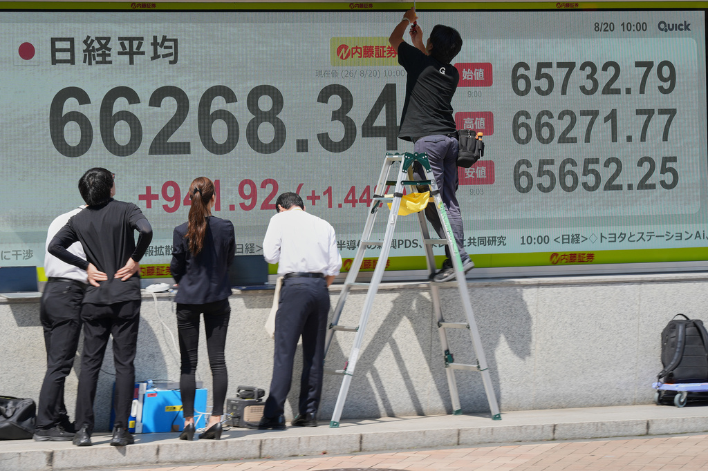Staff arrange an electronic stock board showing Japan's Nikkei index at a securities firm Thursday, Aug. 20, 2026, in Tokyo. (AP Photo/Eugene Hoshiko)