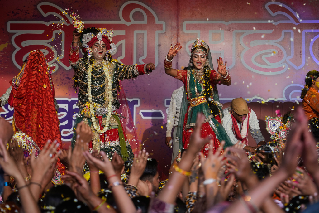 Artists dressed as the Hindu deities Lord Krishna and Radha throw flower petals during Holi festival celebrations at the Shri Krishna Janmabhoomi Temple complex in Mathura, India, on Feb. 27, 2026. (AP Photo/Manish Swarup)