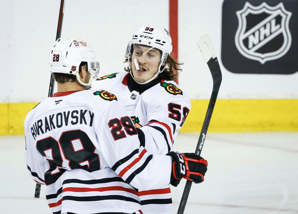 Chicago Blackhawks' Andre Burakovsky, left, celebrates his goal with teammate Tyler Bertuzzi during third period NHL hockey action against the Calgary Flames in Calgary, Friday, Nov. 7, 2025. (Jeff McIntosh/The Canadian Press via AP)