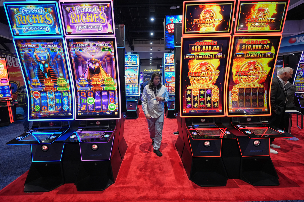 Convention attendees pass displays of gaming products and services at the Indian Gaming Association's annual convention in San Diego, Thursday, April 2, 2026. (AP Photo/Gregory Bull)