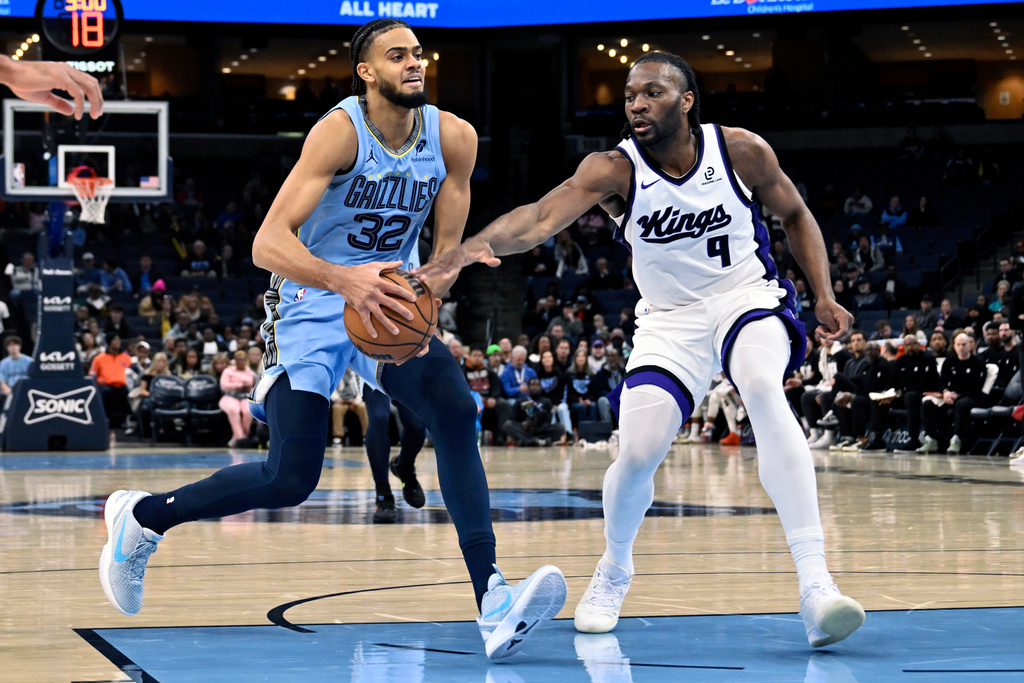 Memphis Grizzlies forward Ryan Rupert (32) drives against Sacramento Kings forward Precious Achiuwa (9) in the first half of an NBA basketball game Monday, Feb. 23, 2026, in Memphis, Tenn. (AP Photo/Brandon Dill)