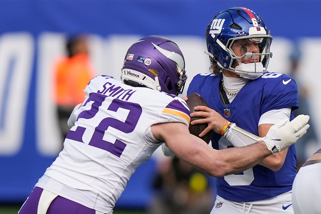 New York Giants quarterback Jaxson Dart (6) looks to pass under pressure from Minnesota Vikings free safety Harrison Smith (22) during the first quarter of an NFL football game, Sunday, Dec. 21, 2025, in East Rutherford, N.J. (AP Photo/Frank Franklin II)