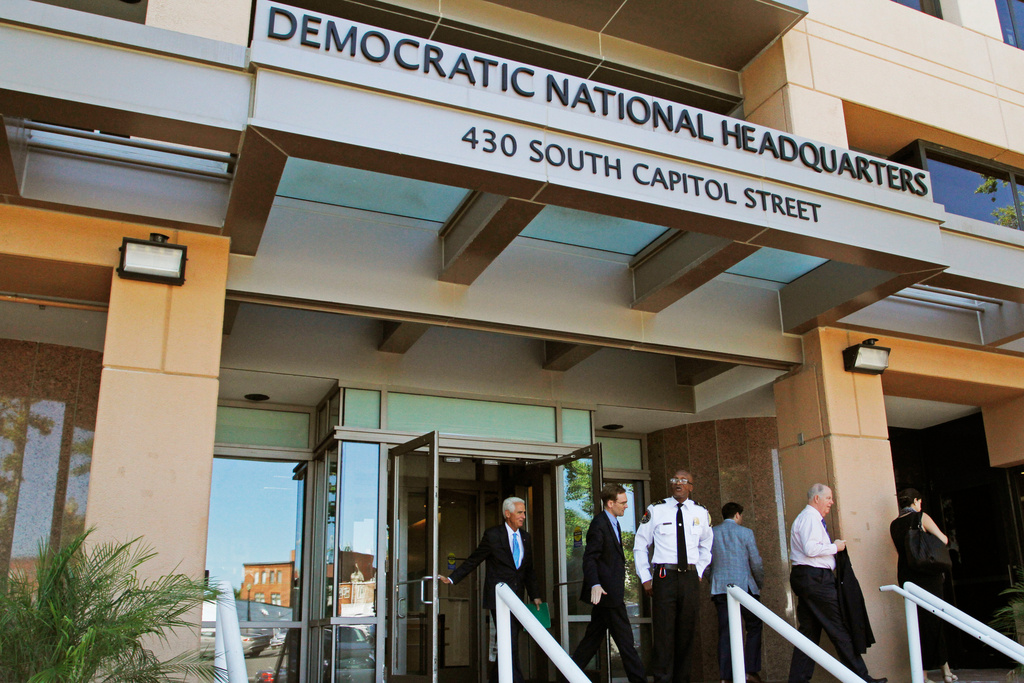 FILE - People stand outside the Democratic National Committee headquarters in Washington, June 14, 2016. (AP Photo/Paul Holston, File)