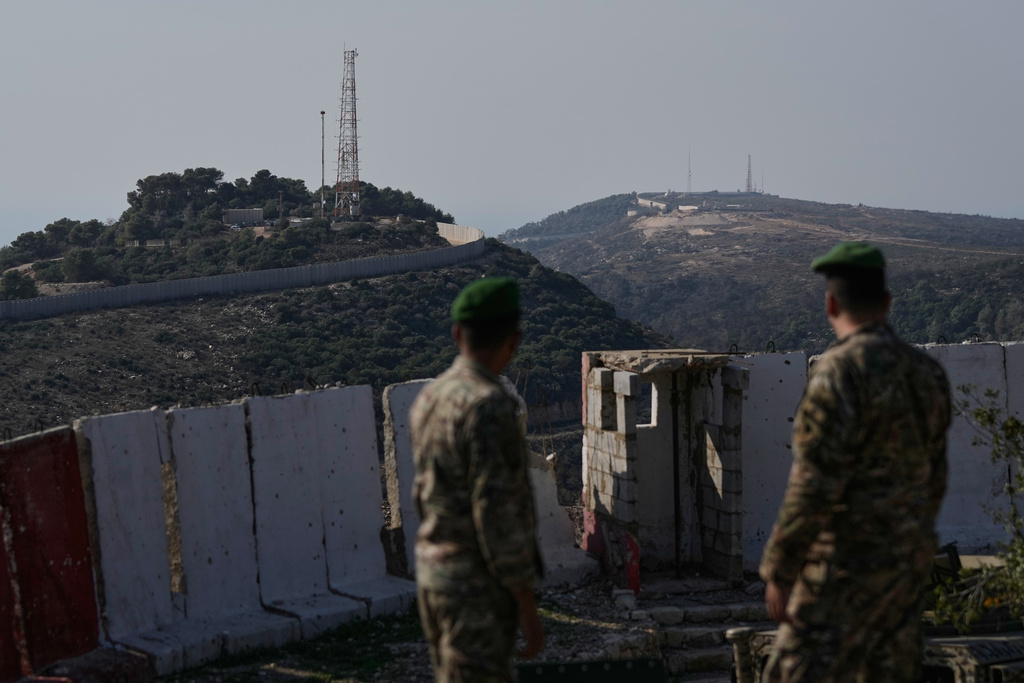 Lebanese army soldiers look at the Israeli military post of Hanita, left, and the Labbouneh post, one of five hills occupied by Israeli forces since last year, right, from a Lebanese military position in the village of Alma al-Shaab in south Lebanon, Friday, Nov. 28, 2025. (AP Photo/Bilal Hussein)