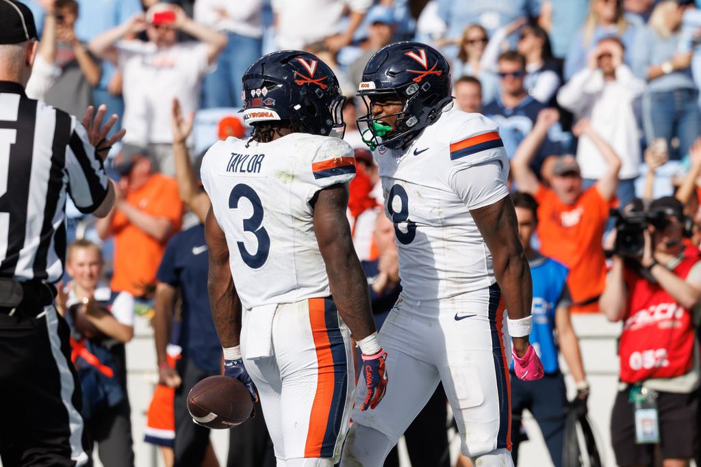 Virginia's J'Mari Taylor (3) and Jayden Thomas (8) celebrate after Taylor scored a touchdown in overtime of an NCAA college football game against North Carolina in Chapel Hill, N.C., Saturday, Oct. 25, 2025. (AP Photo/Ben McKeown)