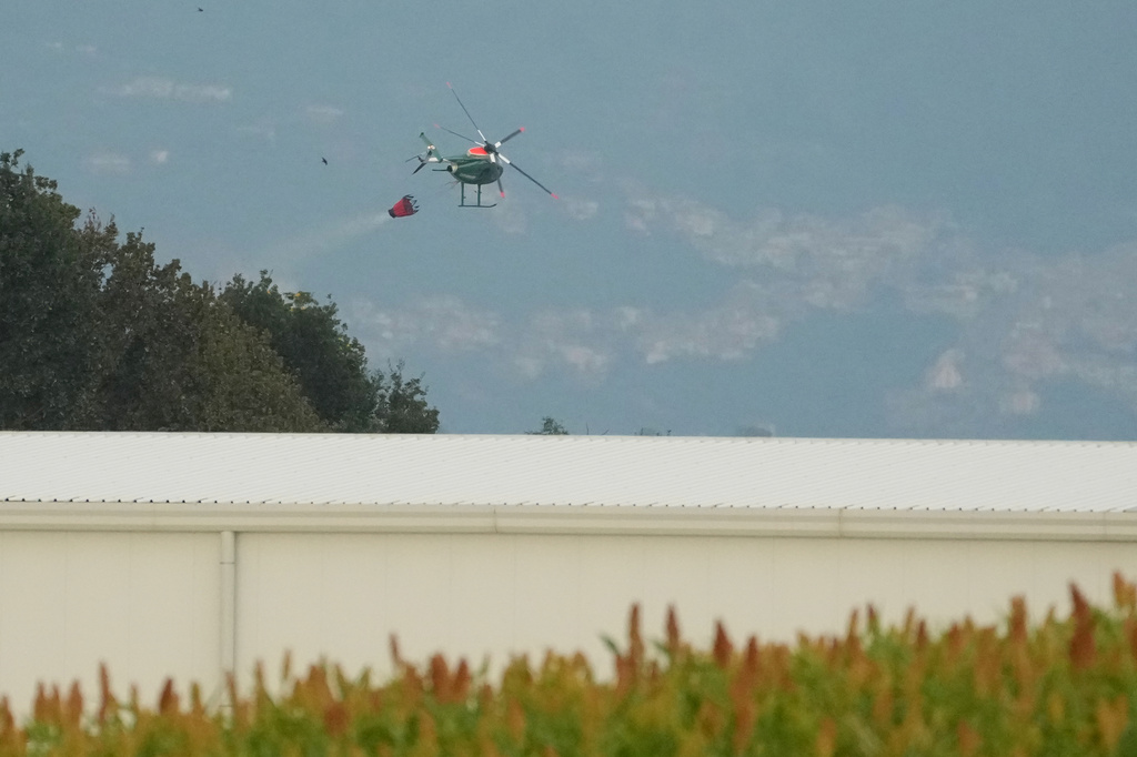 A helicopter drops water over the scene of an explosion at an ammunition plant in Colleferro, near Rome, Thursday, Aug. 13, 2026. (AP Photo/Gregorio Borgia)