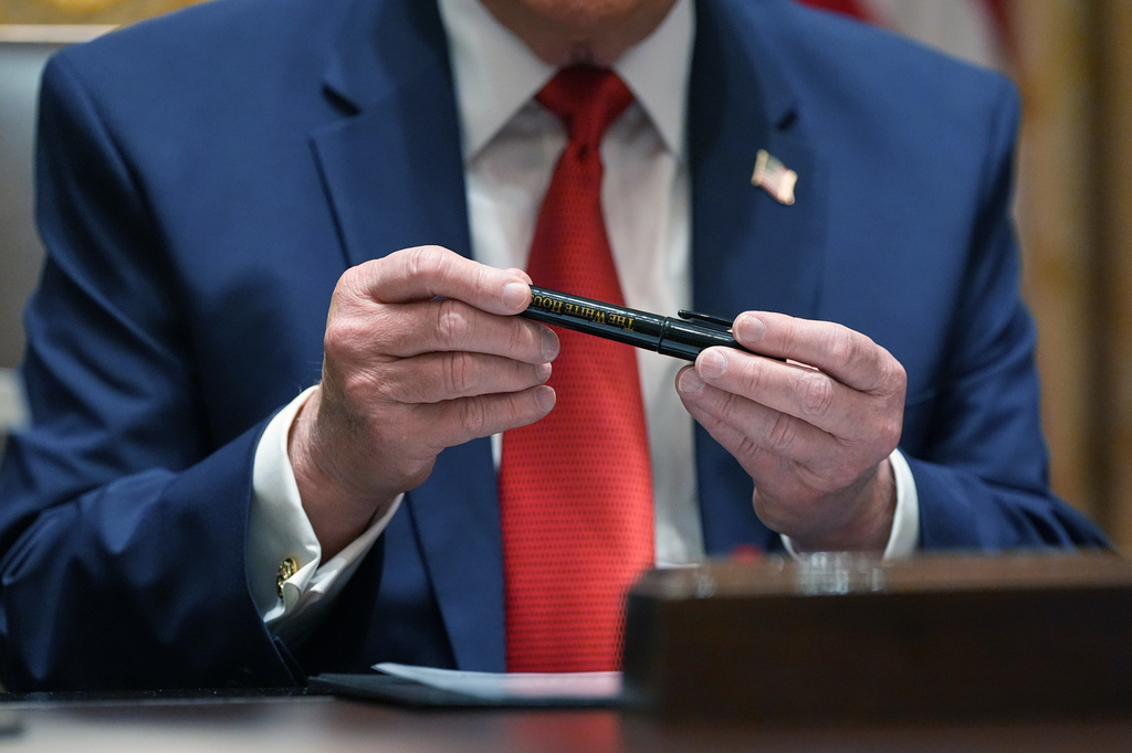 President Donald Trump holds a Sharpie pen he says was produced specifically for the White House during a Cabinet meeting at the White House, Thursday, March 26, 2026, in Washington. (AP Photo/Alex Brandon)